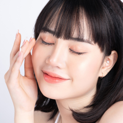 Attractive young Asian woman with fresh and glowing skin on white background