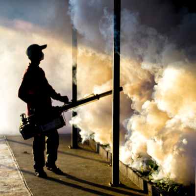 A health worker conducts fogging and fumigation activity on mosquito breeding grounds to combat dengue
